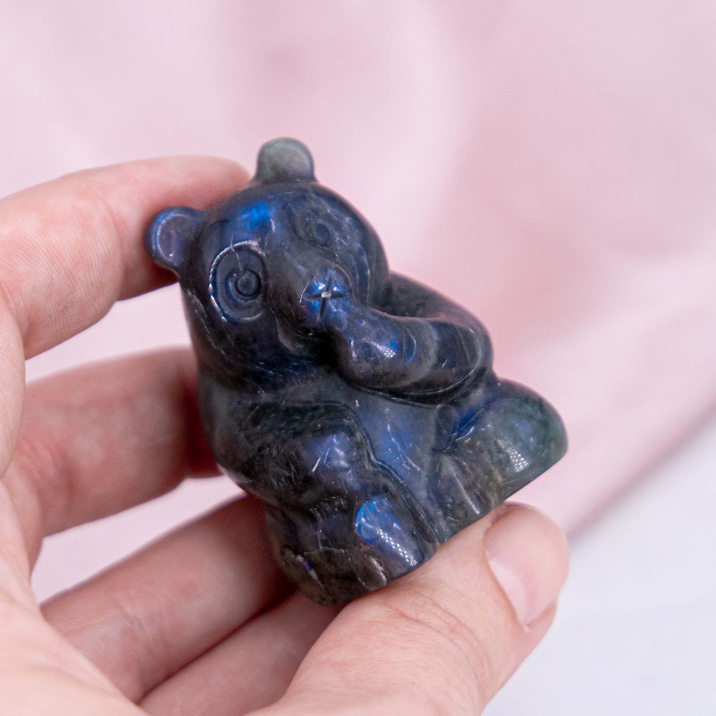 Carving Panda Labradorit Flash grau lila orange blau Tier handgeschnitzt Annurah Crystals deutscher Onlineshop Hand vor dem Mund Amazonas WWF Tierwelt süß Bär