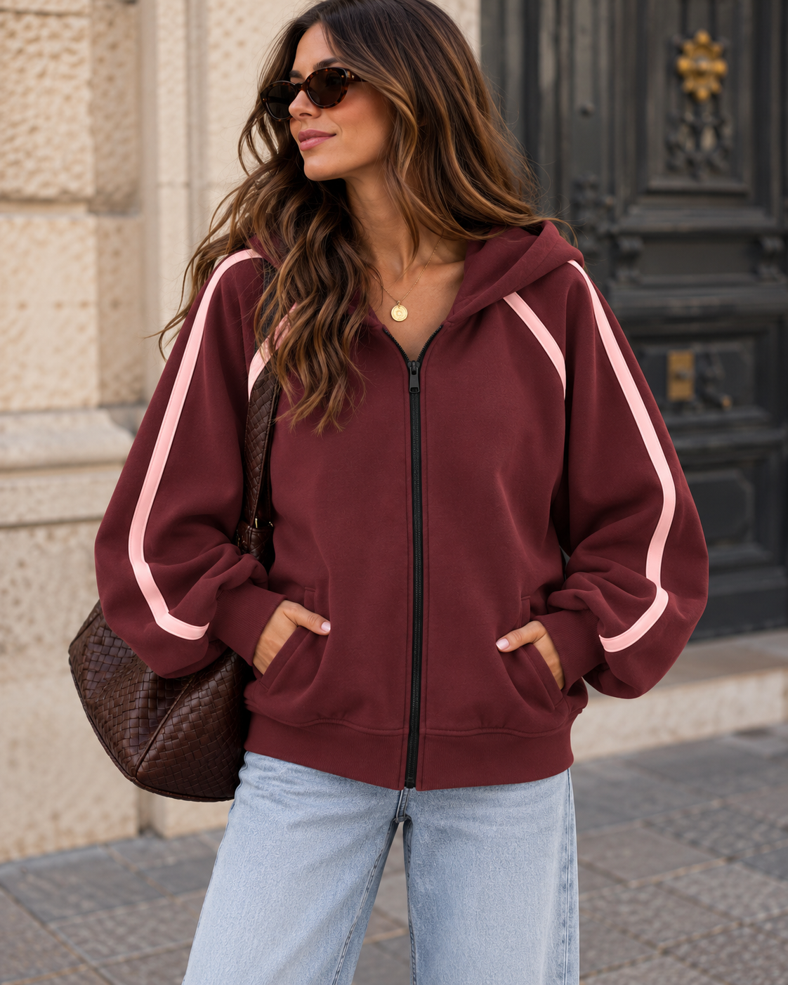 Bordeauxfarbener Zipper Hoodie mit rosa Streifen an den Ärmeln, Kapuze und schwarzem Reißverschluss.