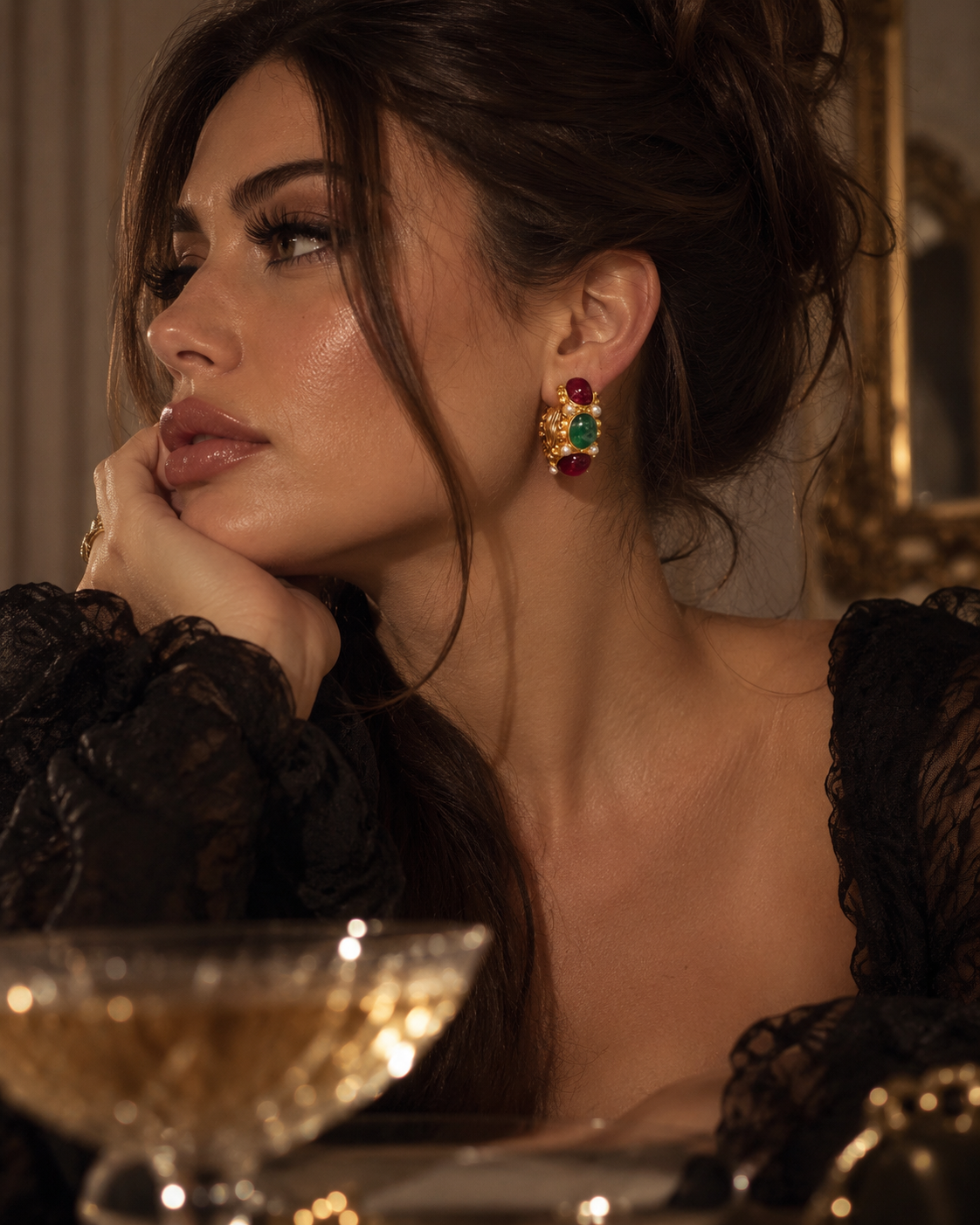Goldene Vintage Glam Creolen aus Edelstahl mit roten und grünen Schmucksteinen und weißen Perlendetails getragen
