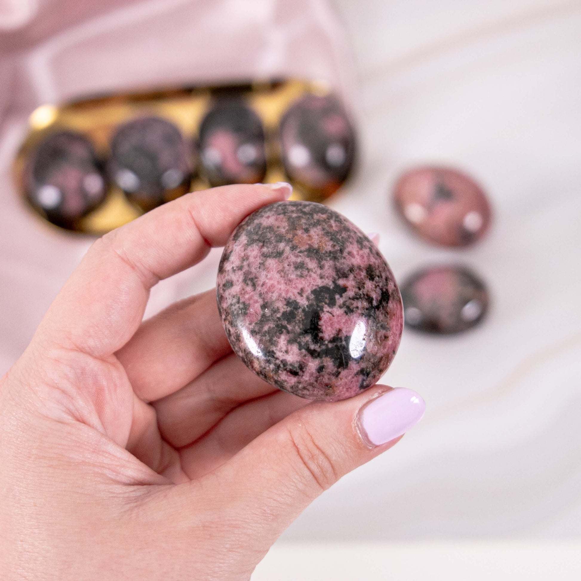 Rhodonit Handstein Seifenstein Trommelstein rosa schwarz Annurah deutscher Onlineshop Kristall Heilstein Edelstein Schutzstein Entgiftung Lunge Magenschmerzen Allergien Asthma Blut Insektenstiche Herz Magersucht Grippe Kreislaufstörungen Schilddrüse Unfruchtbarkeit
