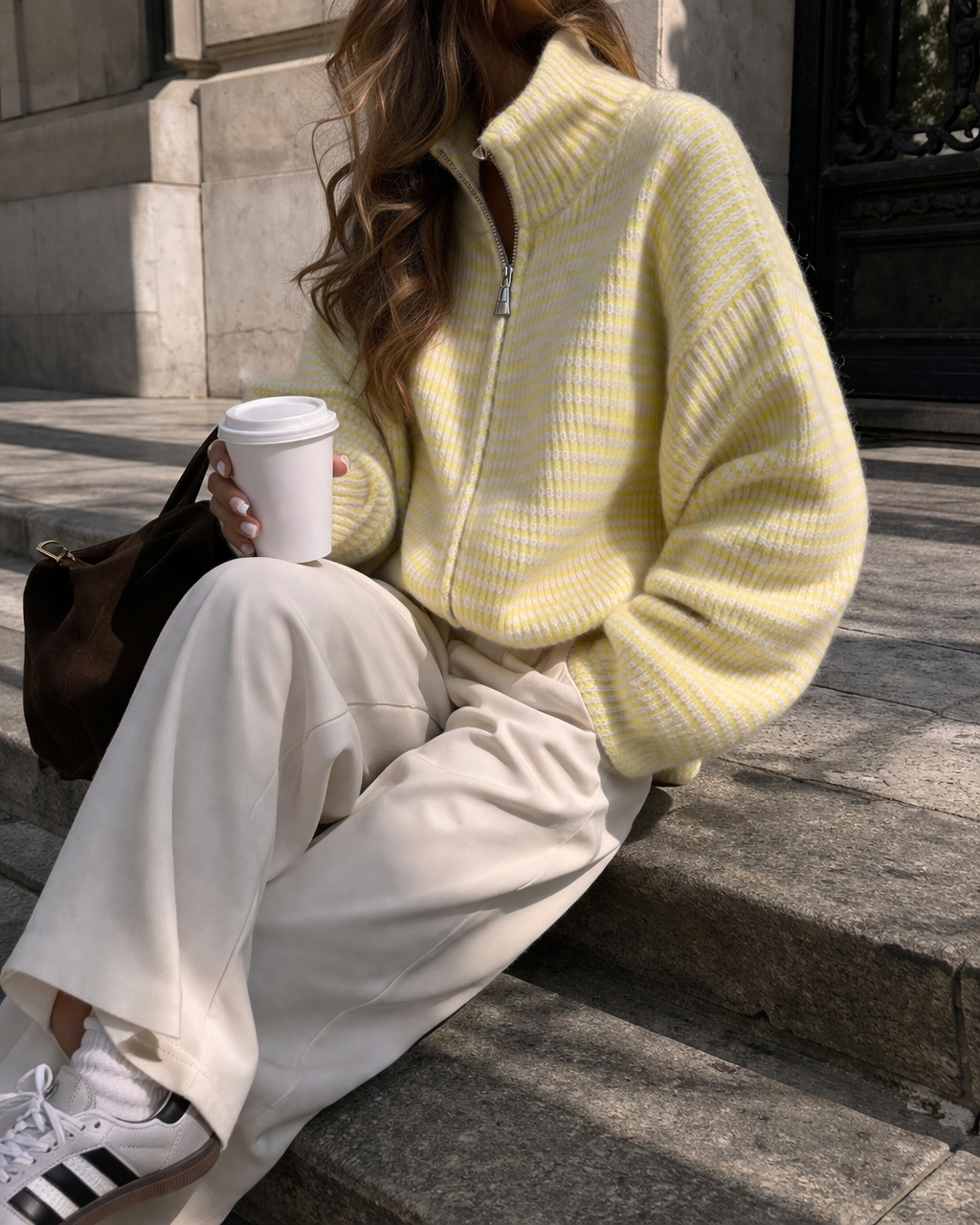 Damen trägt butteryellow gestreifte Strickjacke mit Zipper kombiniert mit Jeans – moderner casual Look